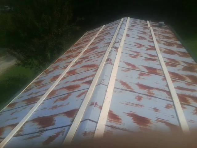 Rusted metal roof panels with new wood purlins before replacement — Storm Damage Roof Repair in Barto by Roofing Brothers